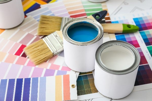 Cans of paint with brushes and palette samples