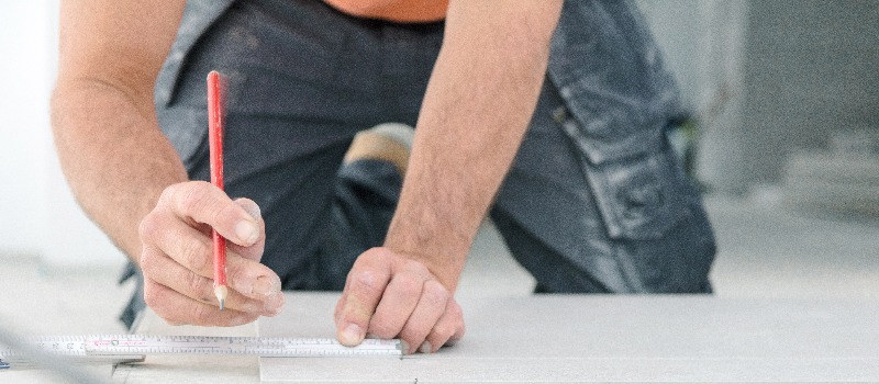 Fliesenleger bei der Arbeit , handwerker schneidet fliesen mit schneidetisch werkzeug