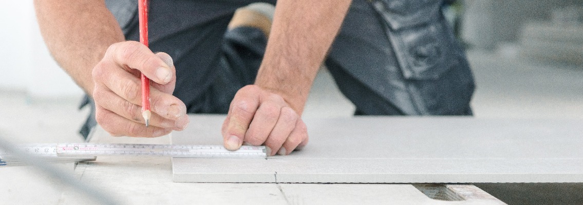 Fliesenleger bei der Arbeit , handwerker schneidet fliesen mit schneidetisch werkzeug